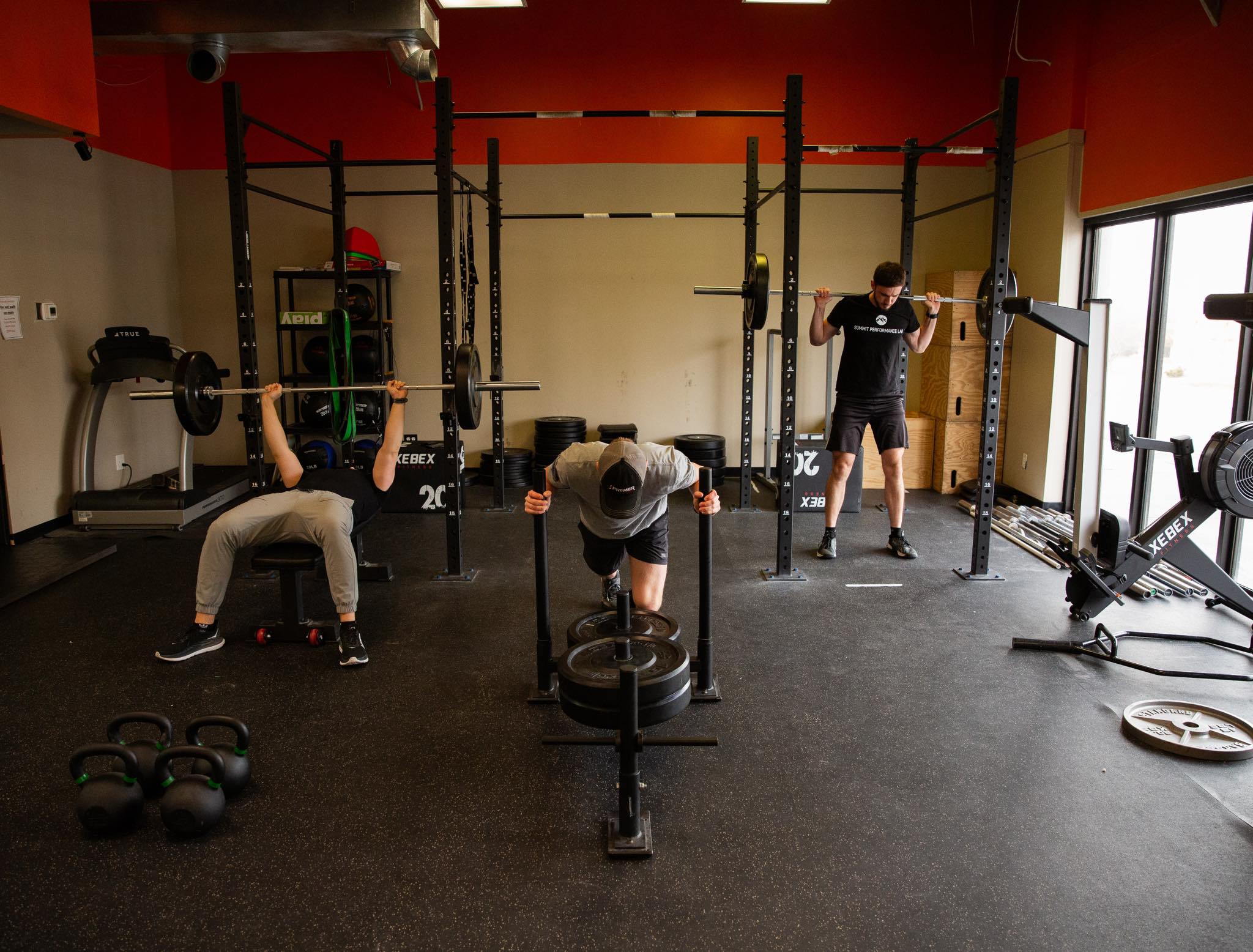 Tactical athletes training with barbells and squat racks at Summit Performance Lab gym